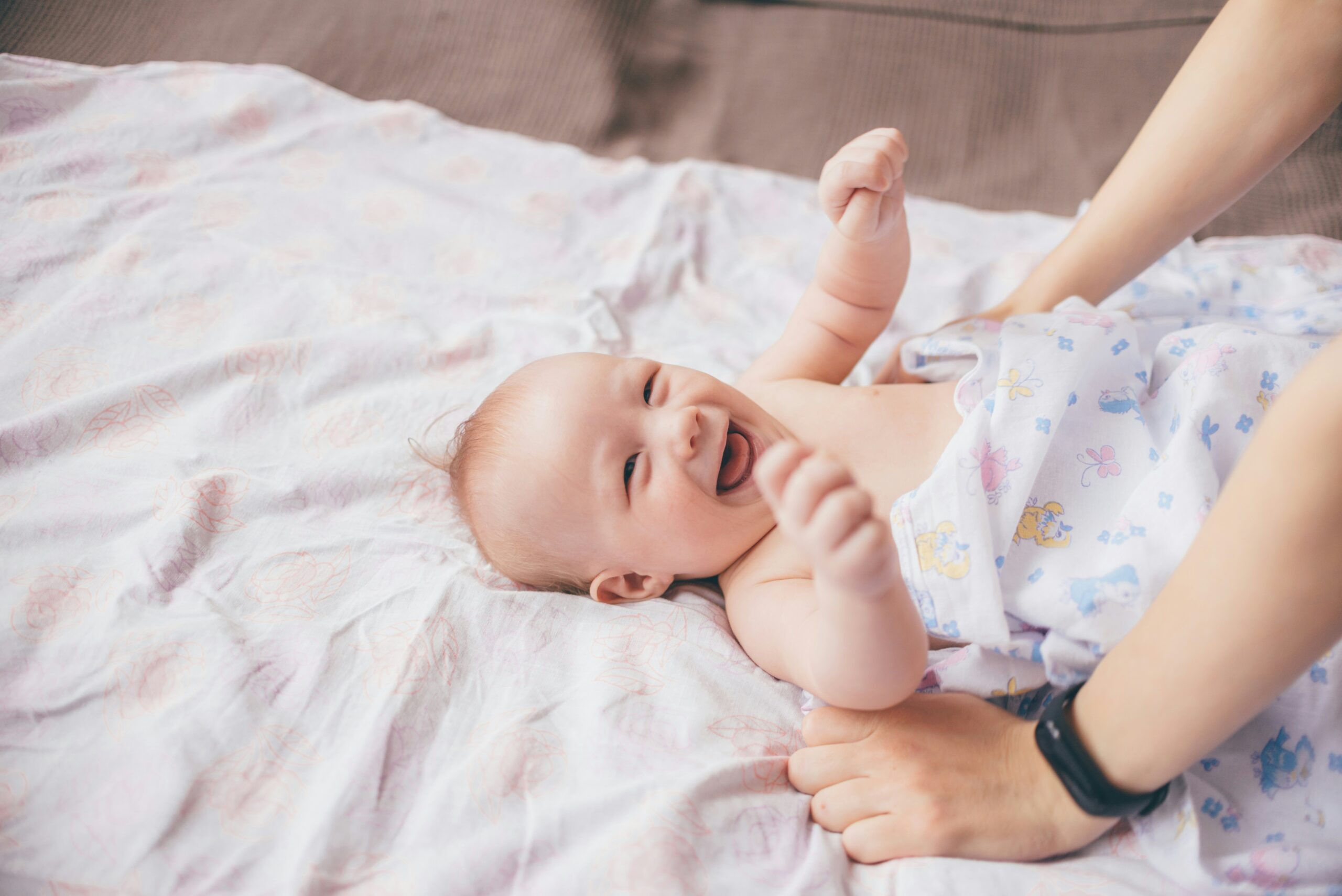 Bambino nei primi mesi su un tappeto morbido durante un momento di osservazione del movimento.