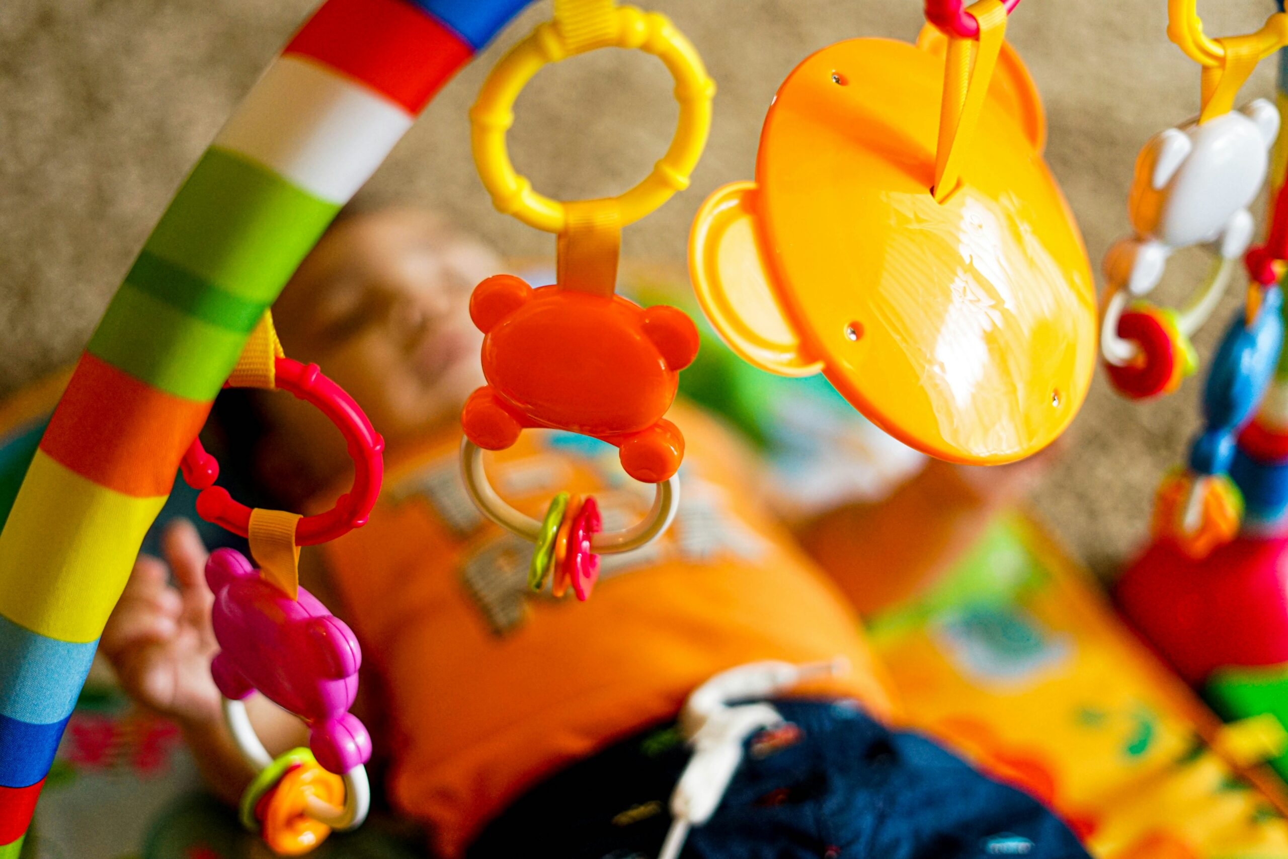 Bambino nei primi mesi disteso su un tappeto durante un momento di movimento