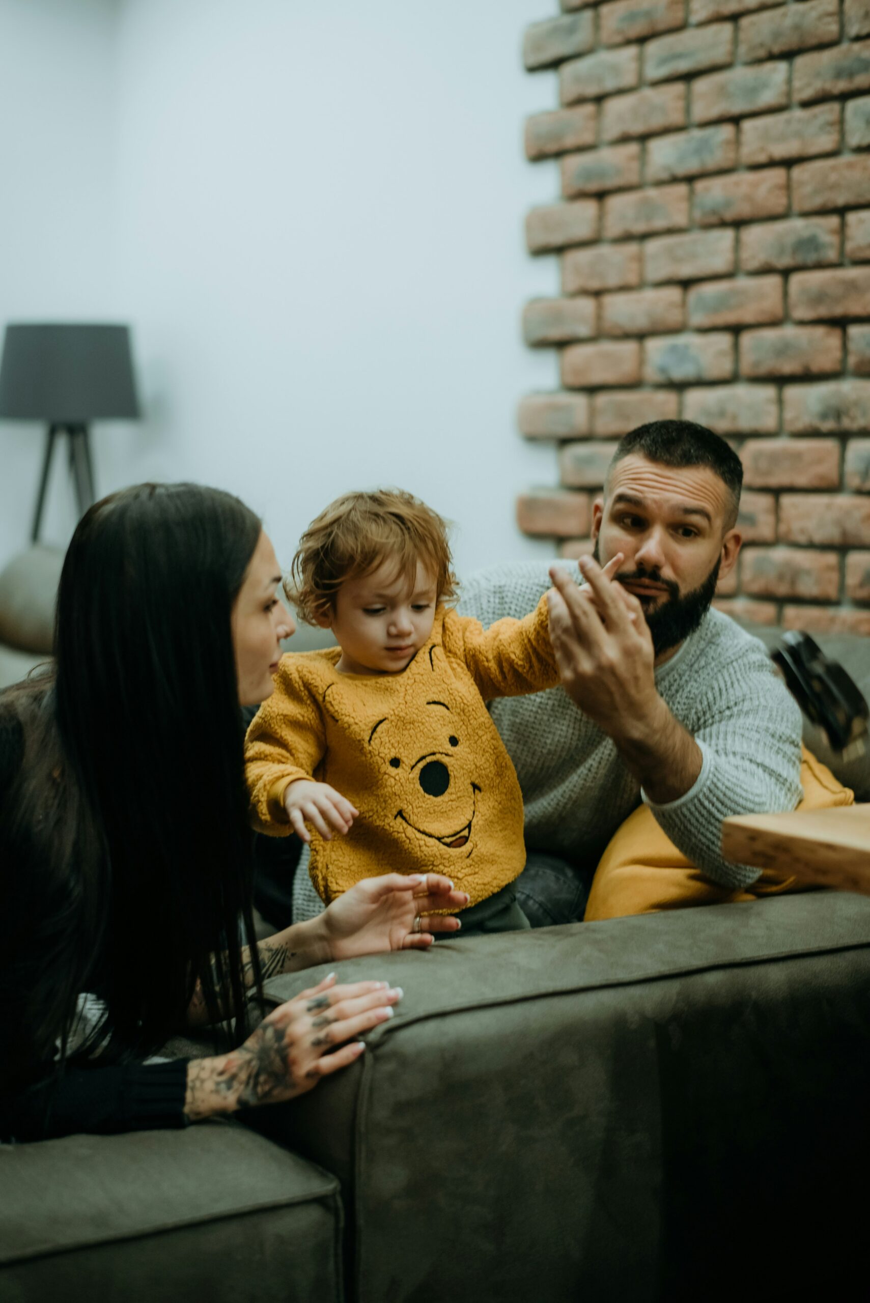 Genitore vicino al bambino durante un momento di gioco, cura e osservazione nei primi mesi.